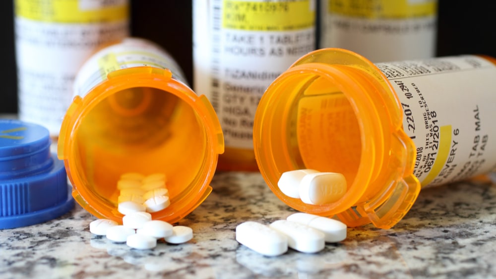 Vicodin Addiction, Abuse, and Treatment - North Jersey Recovery Center - 2 Prescription pill bottles lay on their sides with Vicodin pills spilled out.