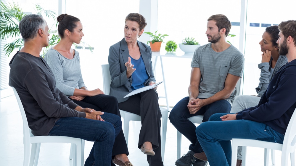 Opiate Addiction, Abuse and Treatment - North Jersey Recovery Center - A small group in therapy listens to their therapist discuss coping mechanisms for their opiate addiction.
