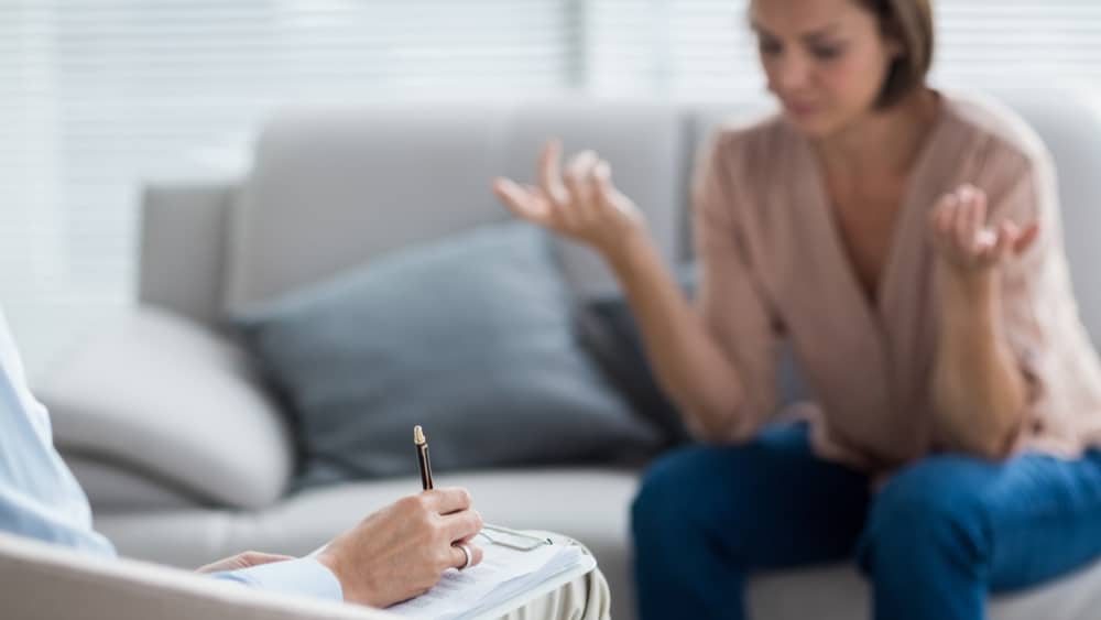 The 7 Types of Alcoholics North Jersey Recovery Center - A young woman is talking with an addiction therapist to determine if she falls into the category of alcoholics and if she needs to enroll in an alcohol rehab program to break free from her addiction to alcohol.