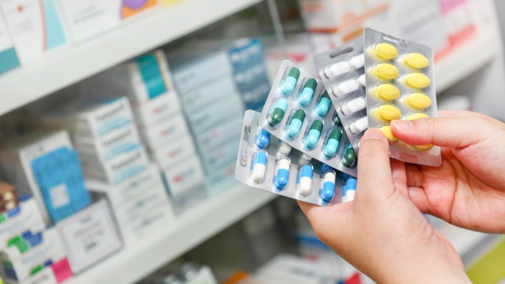 Over-the-Counter Drug Addiction: Abusing OTC Drugs North Jersey Recovery Center - An image of a woman holding various over-the-counter drugs to suffice her over-the-counter drug abuse issues.