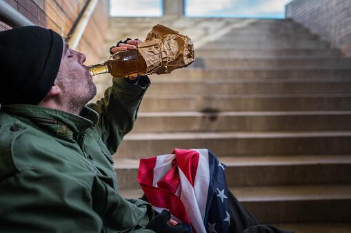 Veteran drinking from alcohol bottle - Veterans & Addiction