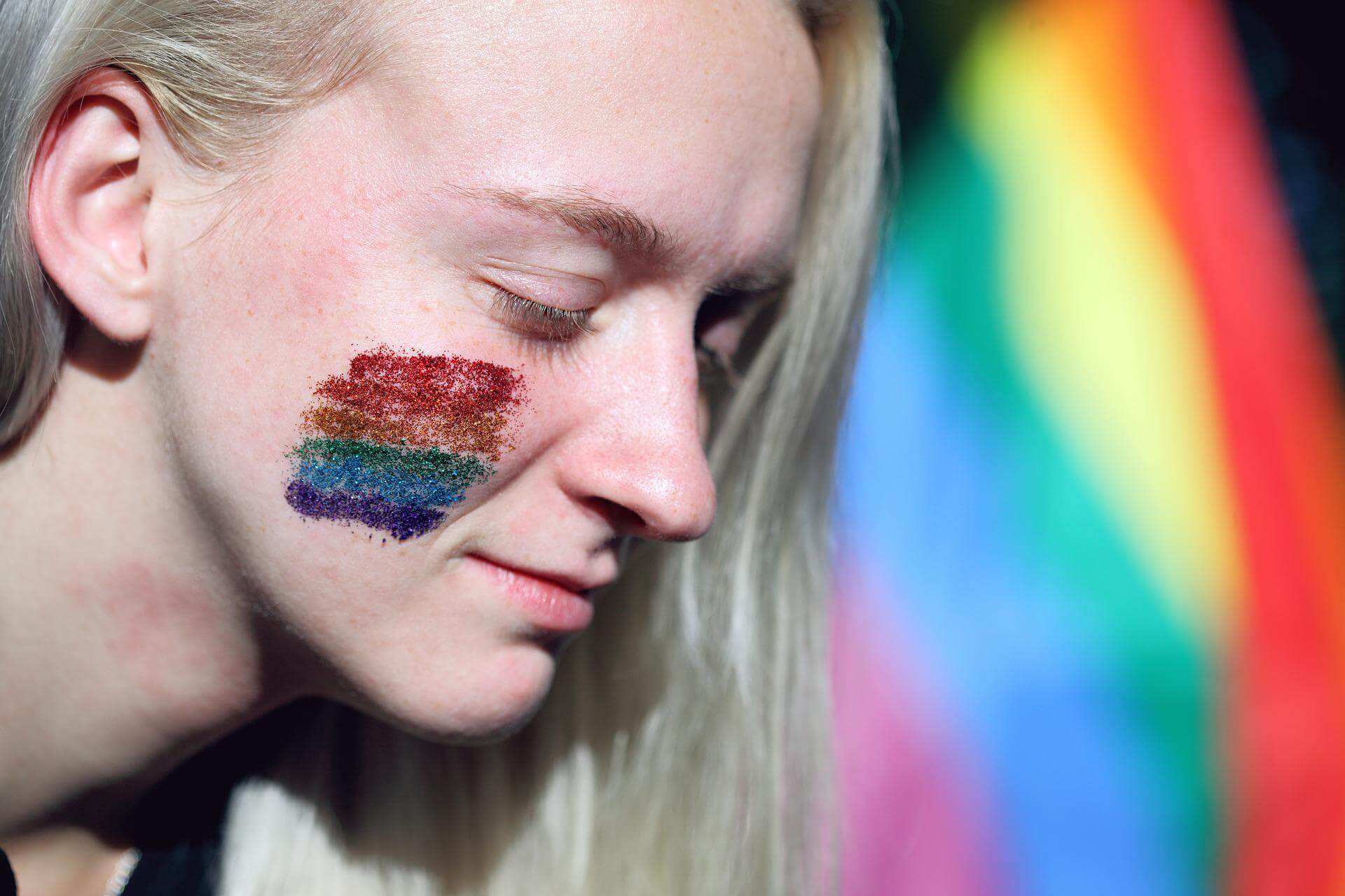 Girl with pride colors painted on face