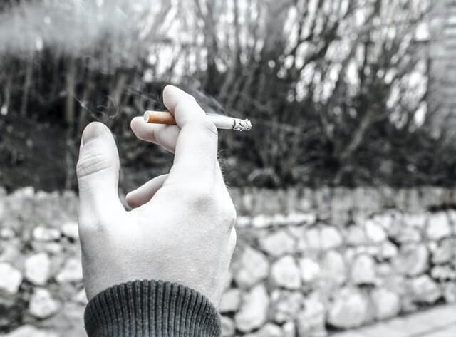 Person holding a cigarette - Nicotine Addiction Affects Work