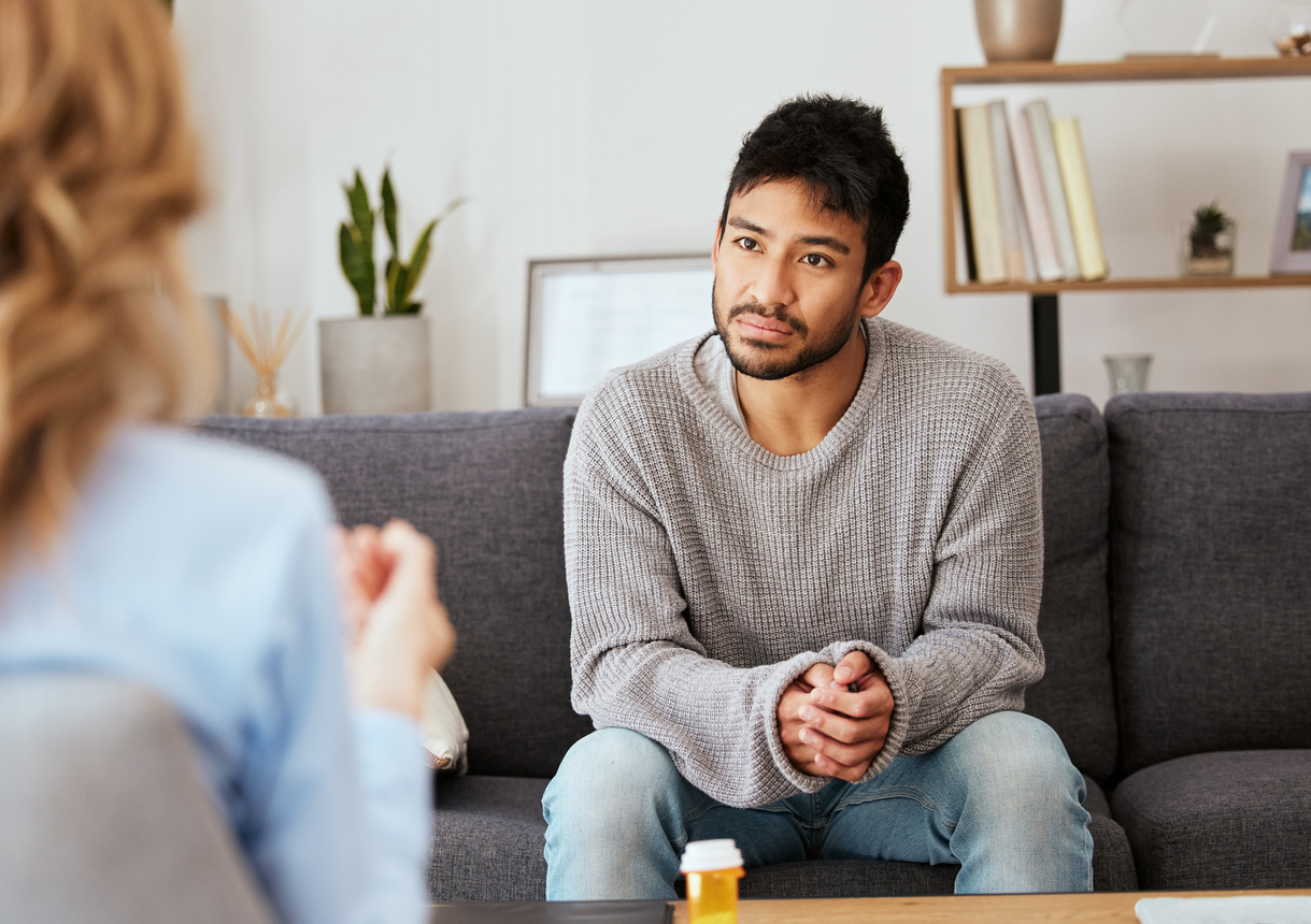 Man on couch speaking with therapist receiving Behavioral Therapy