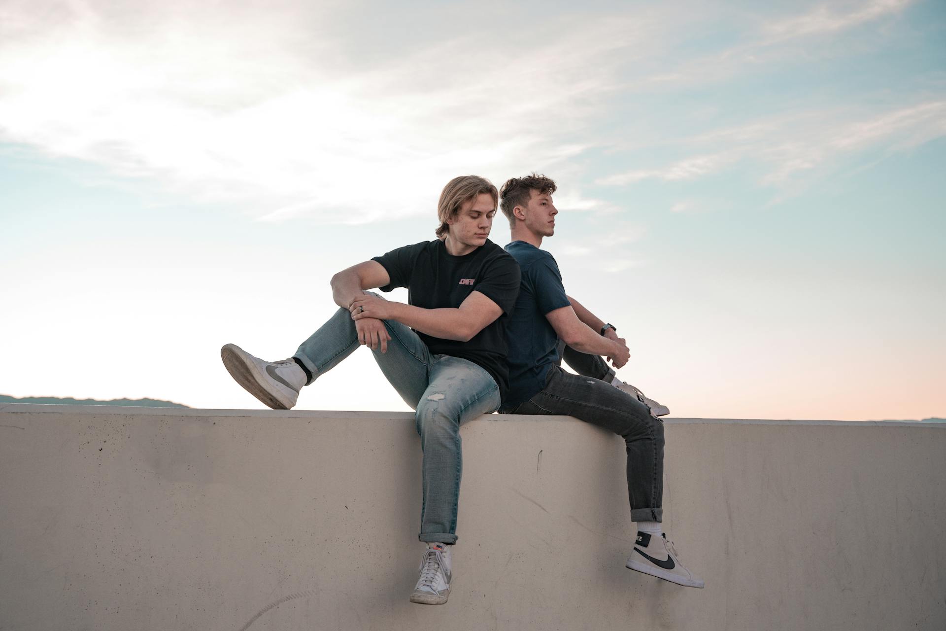men-sitting-on-concrete-wall