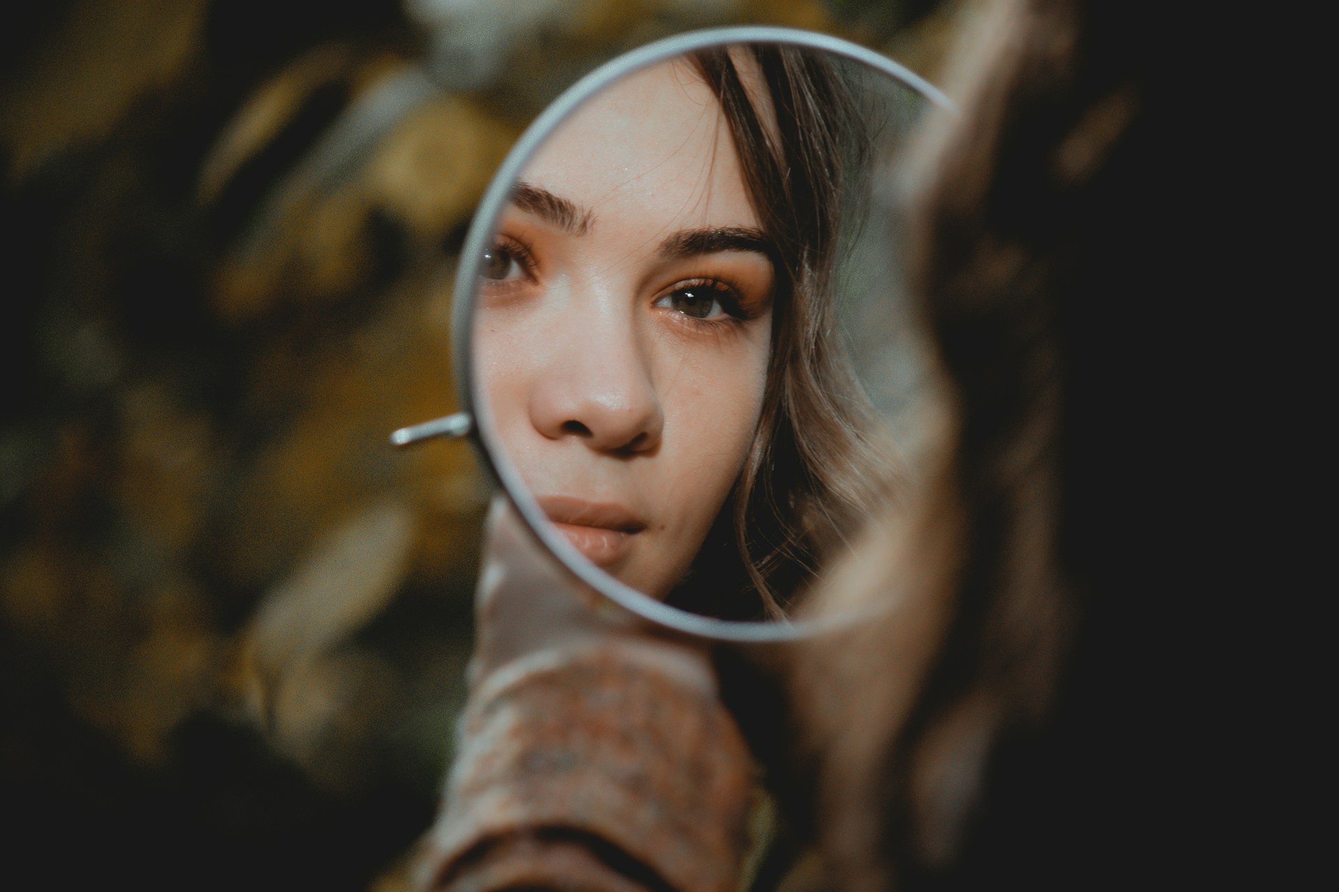 woman-holding-magnifying-glass-with-brown-liquid